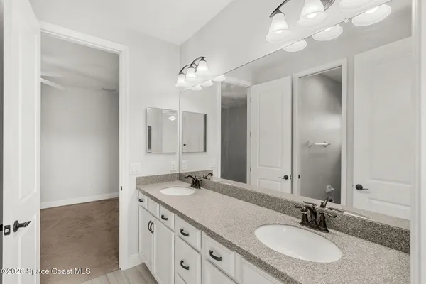 an empty room with windows and ceiling fan