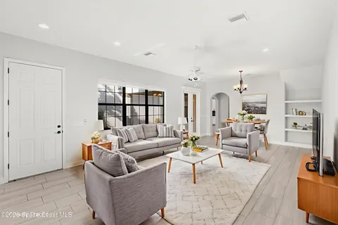 a living room with furniture and a view of kitchen
