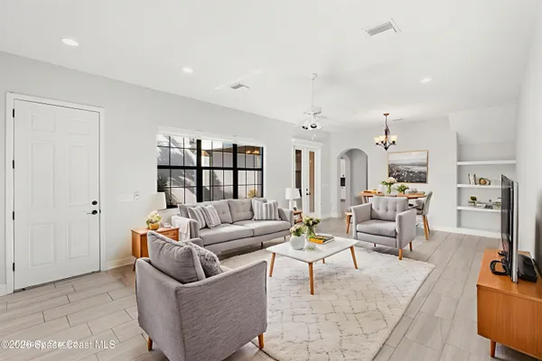 a living room with furniture and a view of kitchen