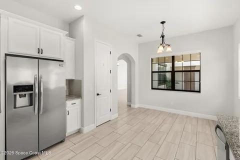 a view of empty room with windows and refrigerator