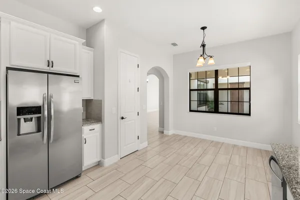 a view of empty room with windows and refrigerator