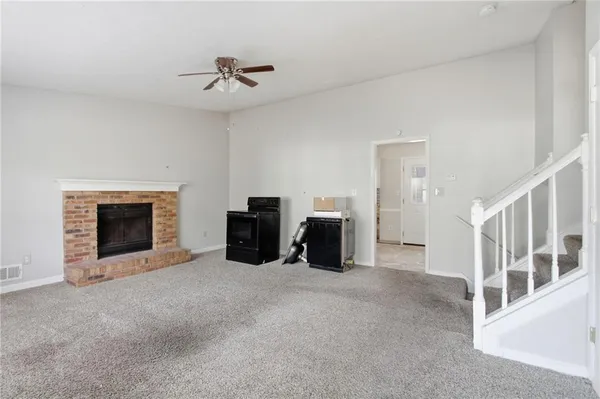 a view of an empty room with furniture and a fireplace