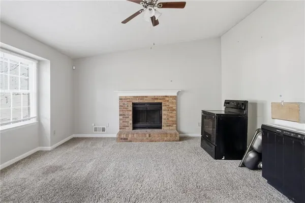 a view of an empty room with a fireplace and a window