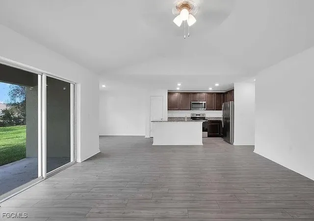 a view of kitchen with granite countertop cabinets and refrigerator