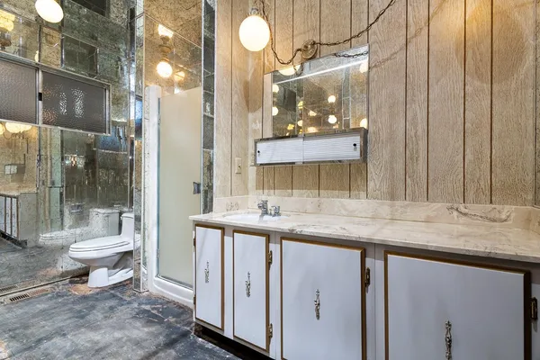 a bathroom with a granite countertop sink a toilet and a mirror
