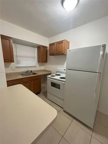 a kitchen with stainless steel appliances a refrigerator sink and microwave