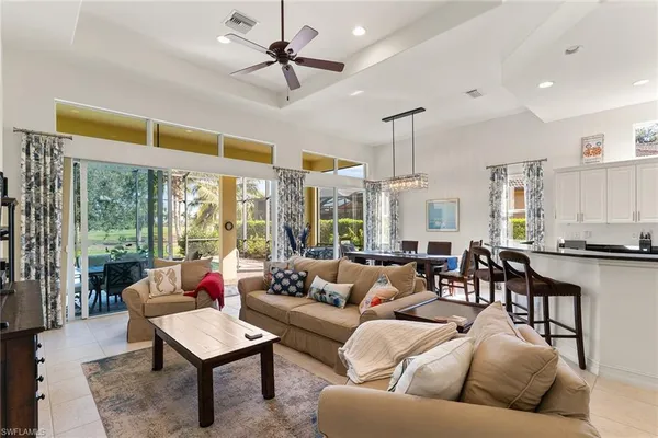 a living room with furniture ceiling fan and a window