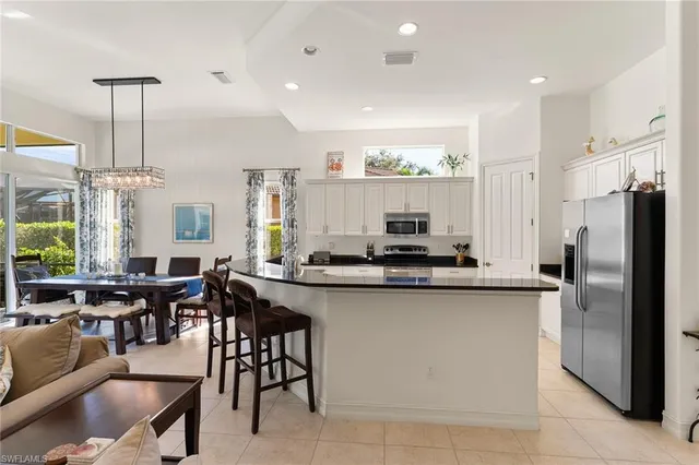 a kitchen with stainless steel appliances granite countertop a table and chairs