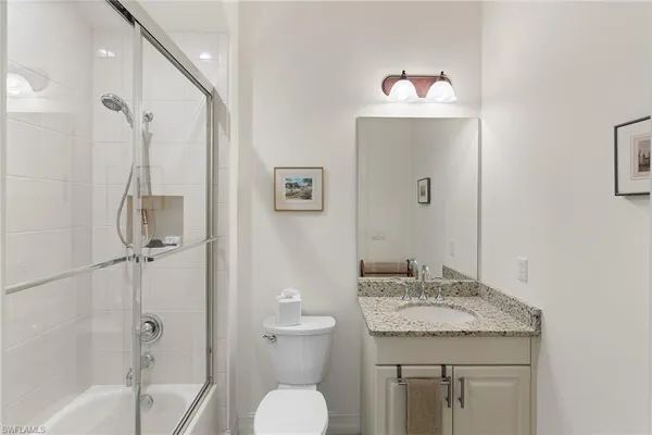 a bathroom with a granite countertop sink toilet and shower
