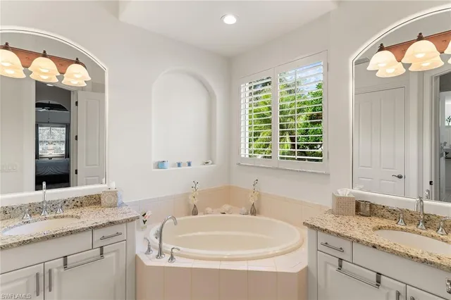 a bathroom with a granite countertop sink and a large mirror