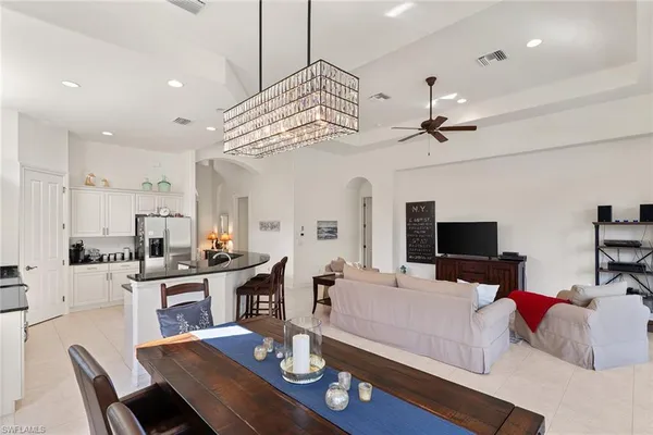 a living room with furniture kitchen view and a wooden floor