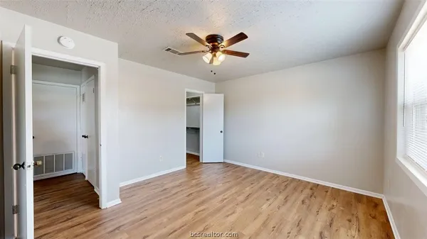 a view of a livingroom with a window and wooden floor