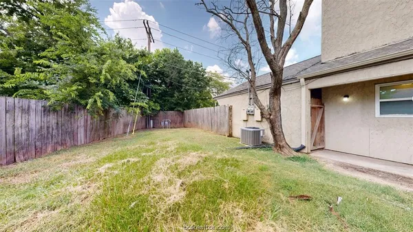 a view of a yard with a house and a large tree