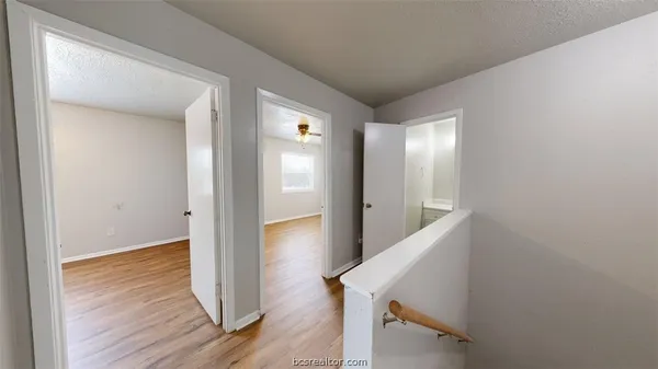 a view of a hallway with wooden floor