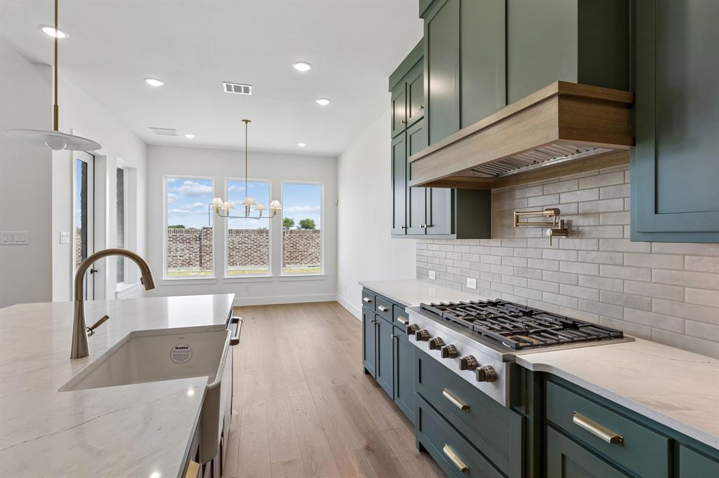 2480 Harpole Road Prosper, TX 75078 - Photo 7 of 20 Beautiful cabinetry, gorgeous counter tops and designer selected backsplash effortlessly pair with contemporary stainless steel to create a kitchen for the ages!