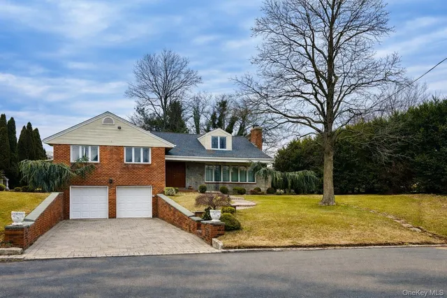 a front view of a house with yard and trees
