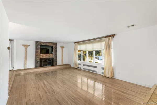 a view of an empty room with a fireplace and a window