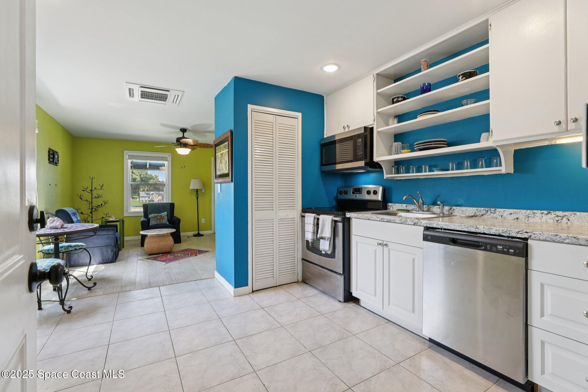 72 Rockledge Avenue Rockledge, FL 32955 - Photo 13 of 28 a kitchen with stainless steel appliances a stove a chimney a refrigerator and furniture