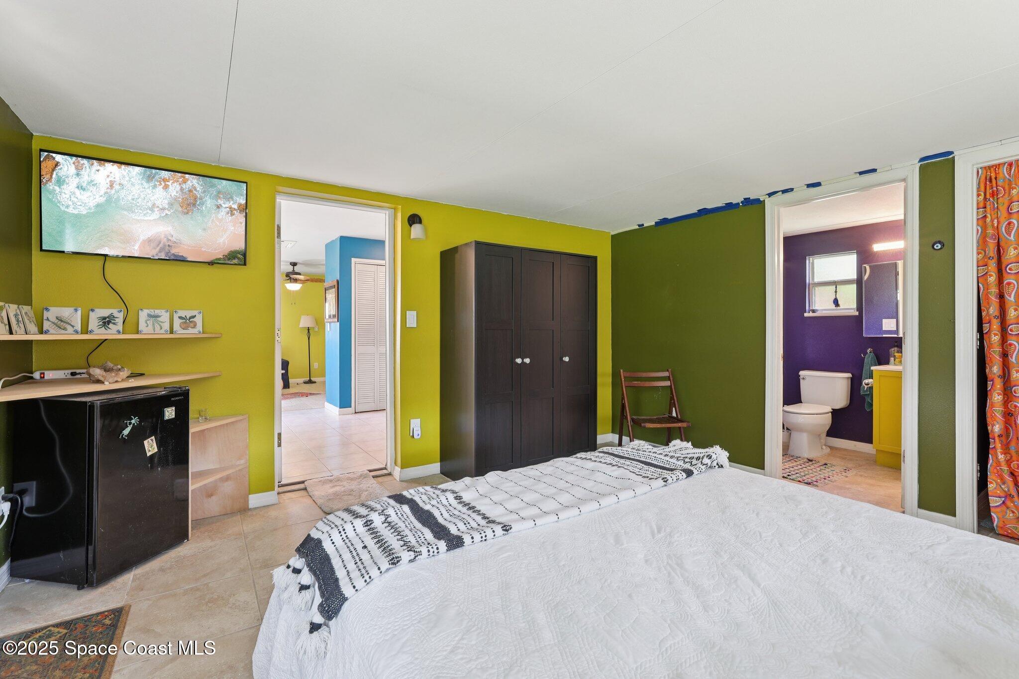 72 Rockledge Avenue Rockledge, FL 32955 - Photo 14 of 28 a bedroom with a bed and a flat tv screen on dresser