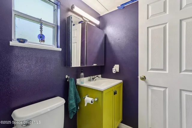 a bathroom with a toilet sink and mirror