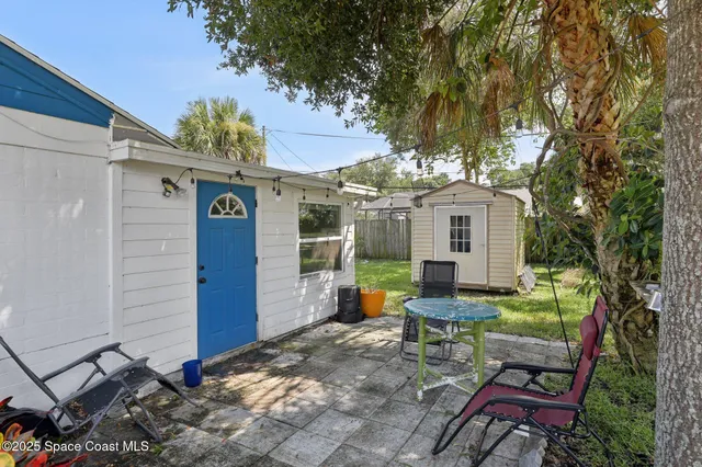 a view of a chairs and table in backyard of the house
