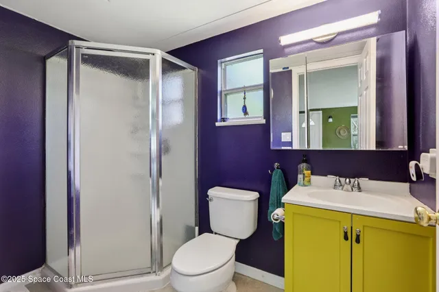 a bathroom with a granite countertop toilet sink and mirror