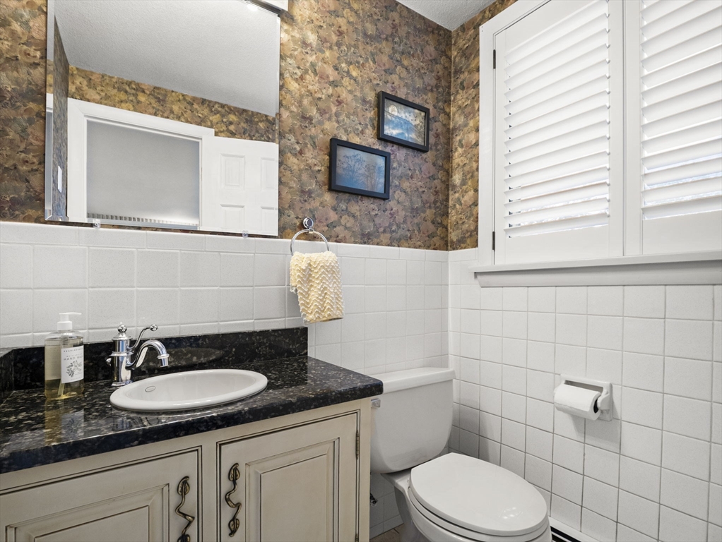 15 North Street Andover, MA 01810 - Photo 9 of 42 a bathroom with a granite countertop sink and a mirror
