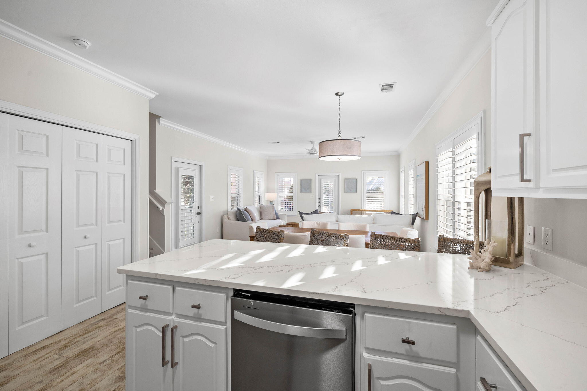 482 Hidden Lake Way Santa Rosa Beach, FL 32459 - Photo 19 of 51 a kitchen with a sink dishwasher and white cabinets with wooden floor