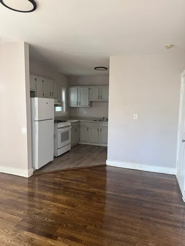 a kitchen with wooden floors and white appliances