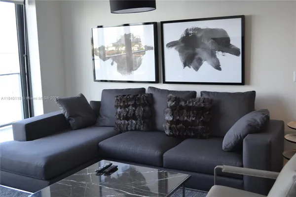 a living room with furniture and a painting on the wall