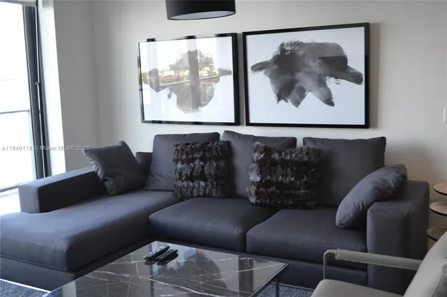 a living room with furniture and a painting on the wall