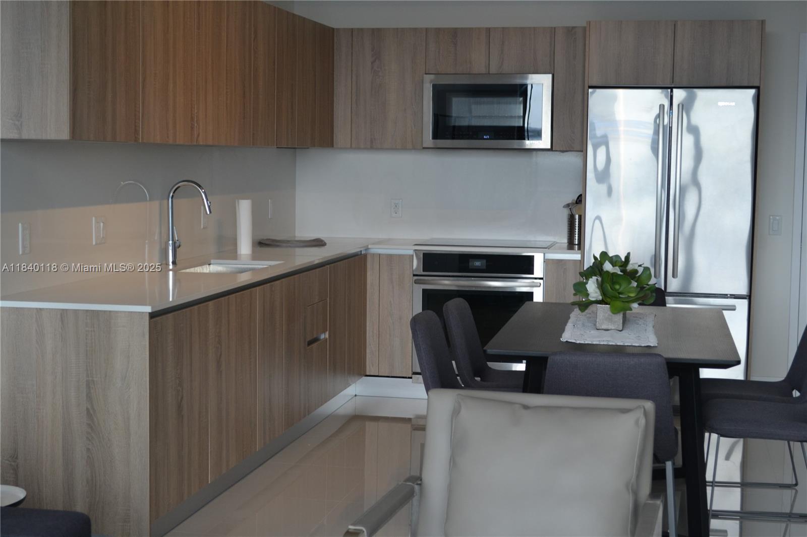 2960 Northeast 207th Street, Unit 1204 Aventura, FL 33180 - Photo 20 of 28 a kitchen with stainless steel appliances a sink a microwave a refrigerator and a stove