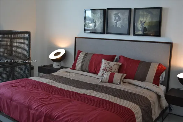 a bedroom with a bed and painting on the wall