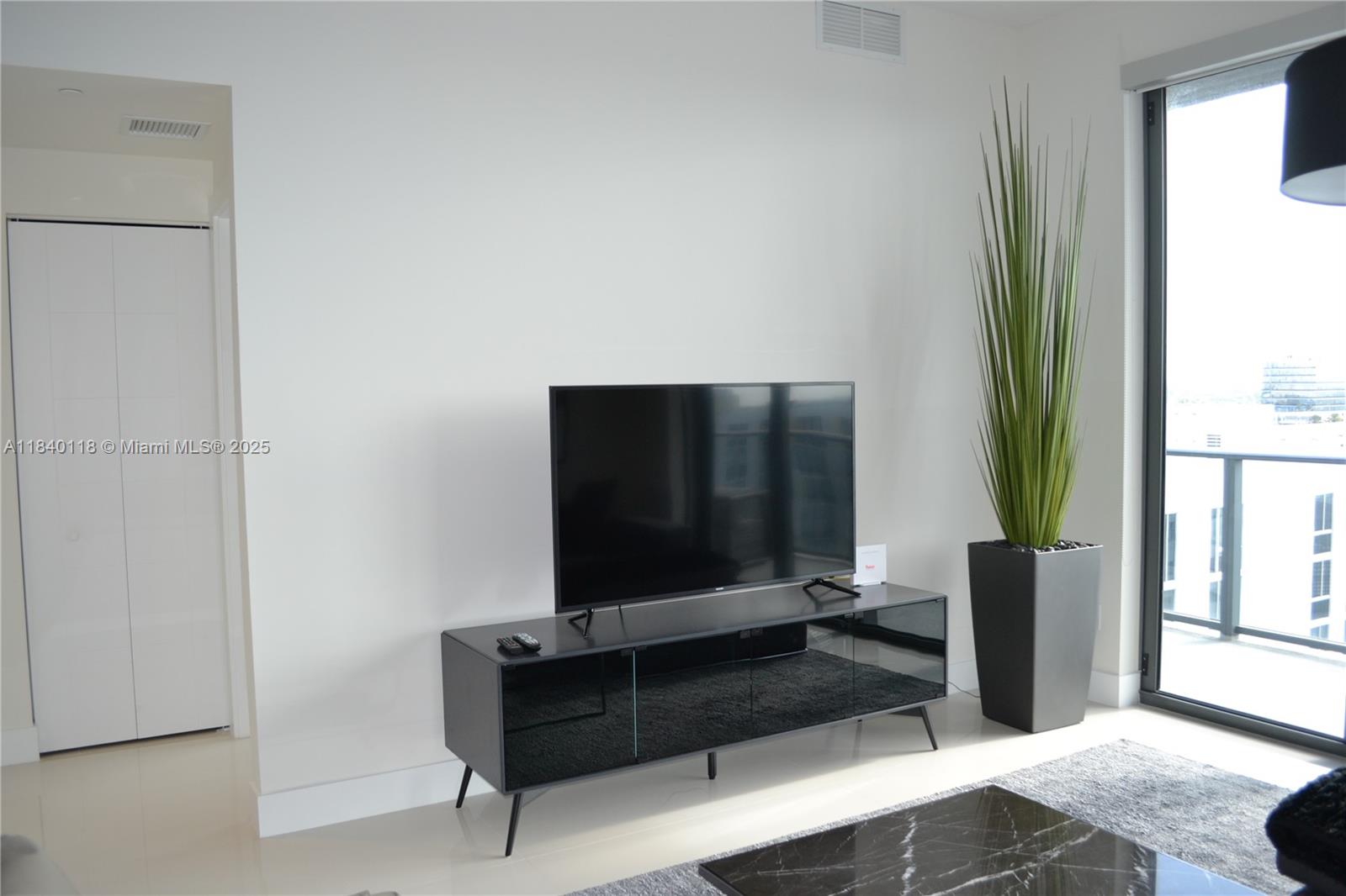 2960 Northeast 207th Street, Unit 1204 Aventura, FL 33180 - Photo 24 of 28 a bedroom with a bed and a flat screen tv