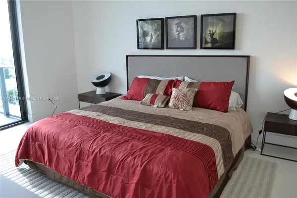 a bedroom with a bed and painting on the wall