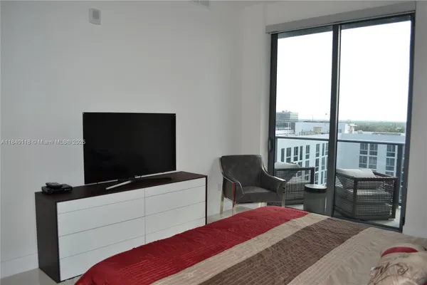 a bedroom with a bed and a flat screen tv