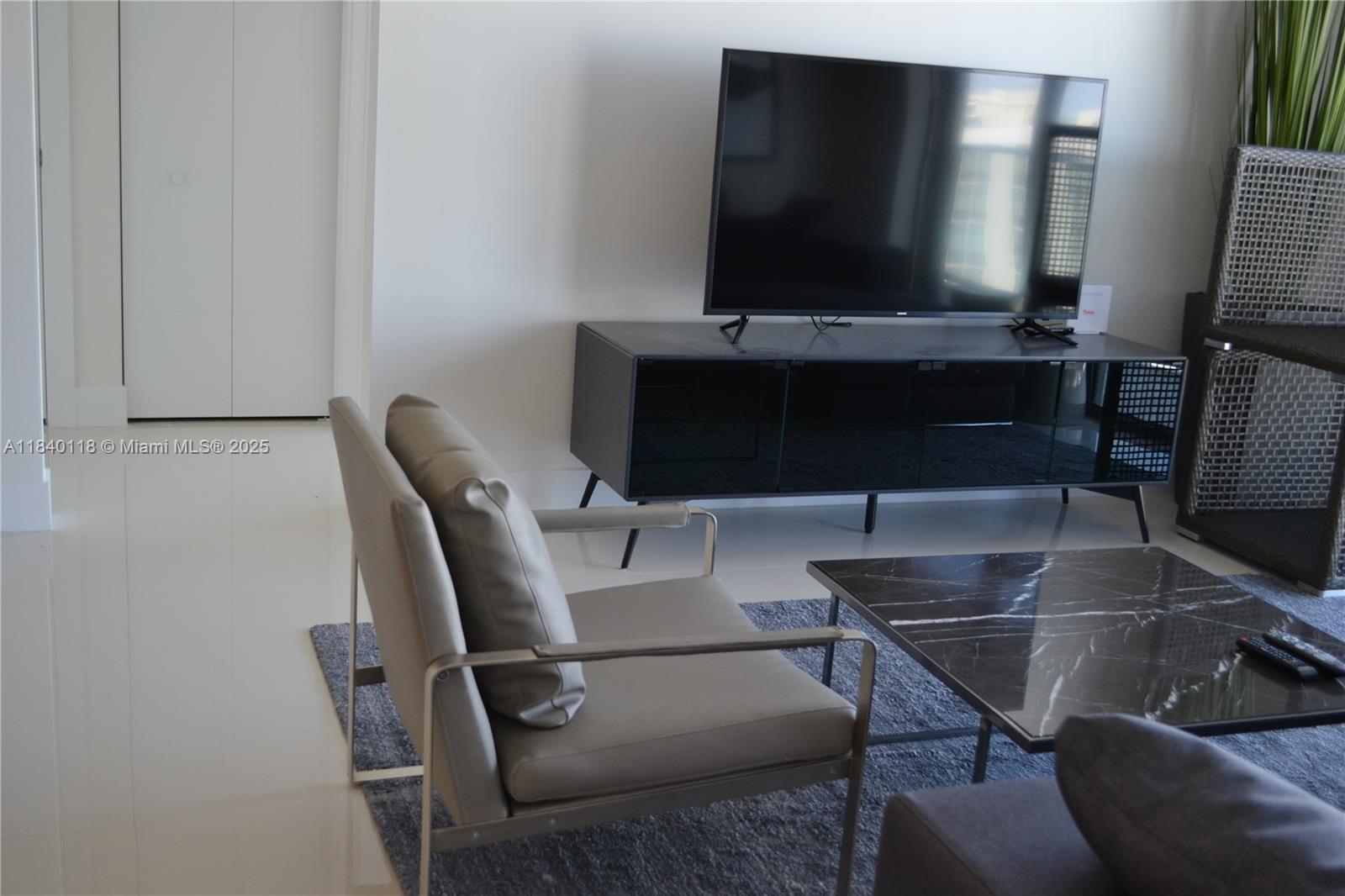 2960 Northeast 207th Street, Unit 1204 Aventura, FL 33180 - Photo 3 of 28 a living room with furniture and a flat screen tv