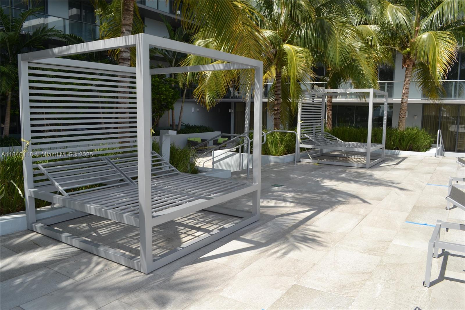 2960 Northeast 207th Street, Unit 1204 Aventura, FL 33180 - Photo 8 of 28 a view of backyard with wheel chair potted plants and palm trees