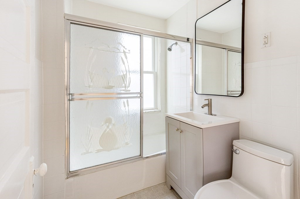 52-54 Gold Star Road Cambridge, MA 02140 - Photo 35 of 36 a bathroom with a shower sink vanity and mirror
