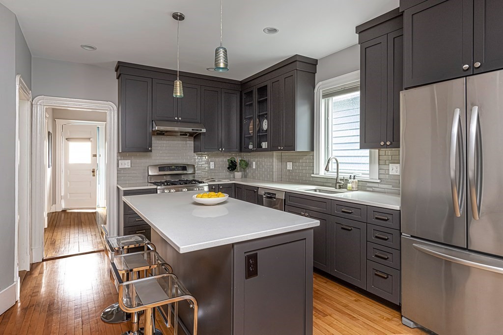 52-54 Gold Star Road Cambridge, MA 02140 - Photo 8 of 36 a kitchen with a refrigerator a sink dishwasher and white cabinets with wooden floor