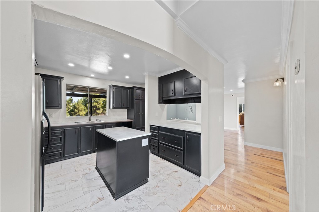 22350 Gavilan Road Perris, CA 92570 - Photo 4 of 34 a kitchen with kitchen island granite countertop stainless steel appliances stove sink and cabinets