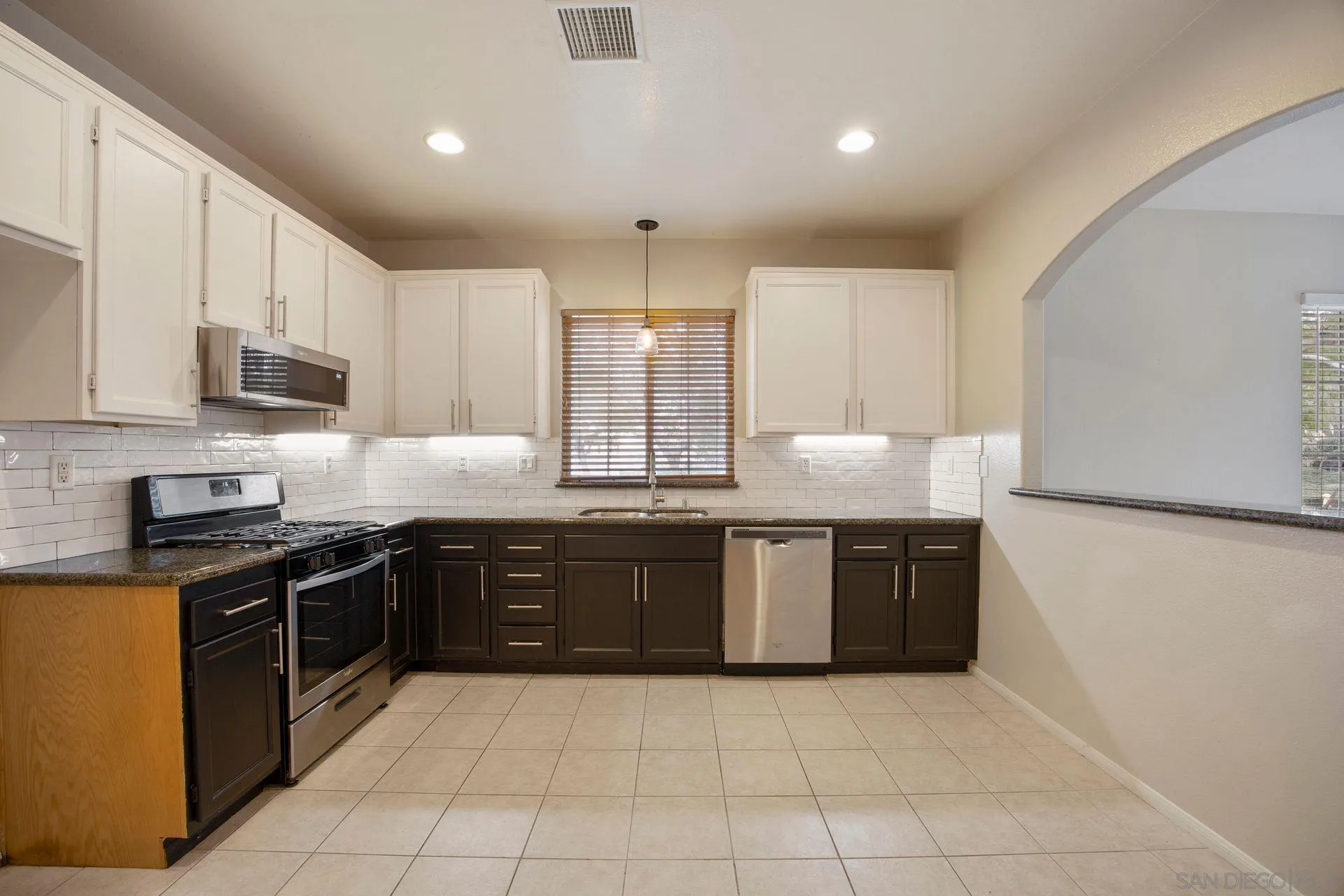 4058 Craven Road, Unit 53 Oceanside, CA 92057 - Photo 13 of 31 a large kitchen with granite countertop a stove a sink dishwasher and a refrigerator