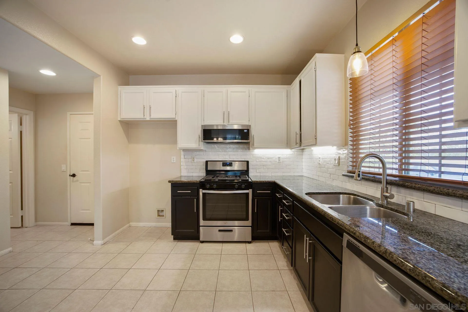 4058 Craven Road, Unit 53 Oceanside, CA 92057 - Photo 14 of 31 a kitchen with stainless steel appliances granite countertop a sink stove and refrigerator