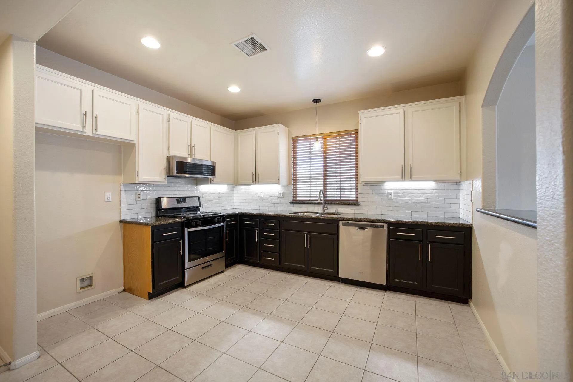 4058 Craven Road, Unit 53 Oceanside, CA 92057 - Photo 15 of 31 a large kitchen with granite countertop a stove top oven a sink dishwasher and a refrigerator with wooden cabinets