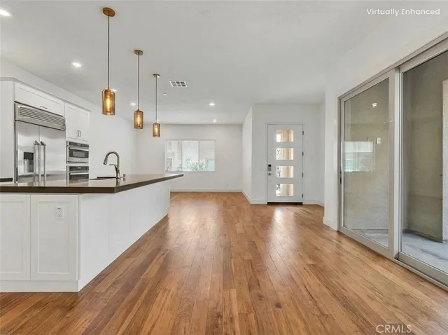 a view of large kitchen with a sink and wooden floor