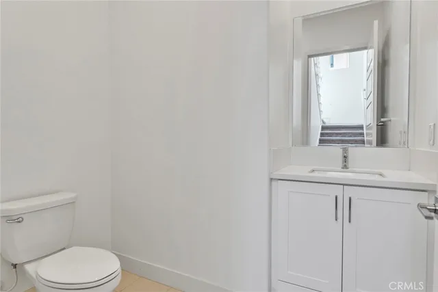 a bathroom with a toilet a sink a vanity and mirror