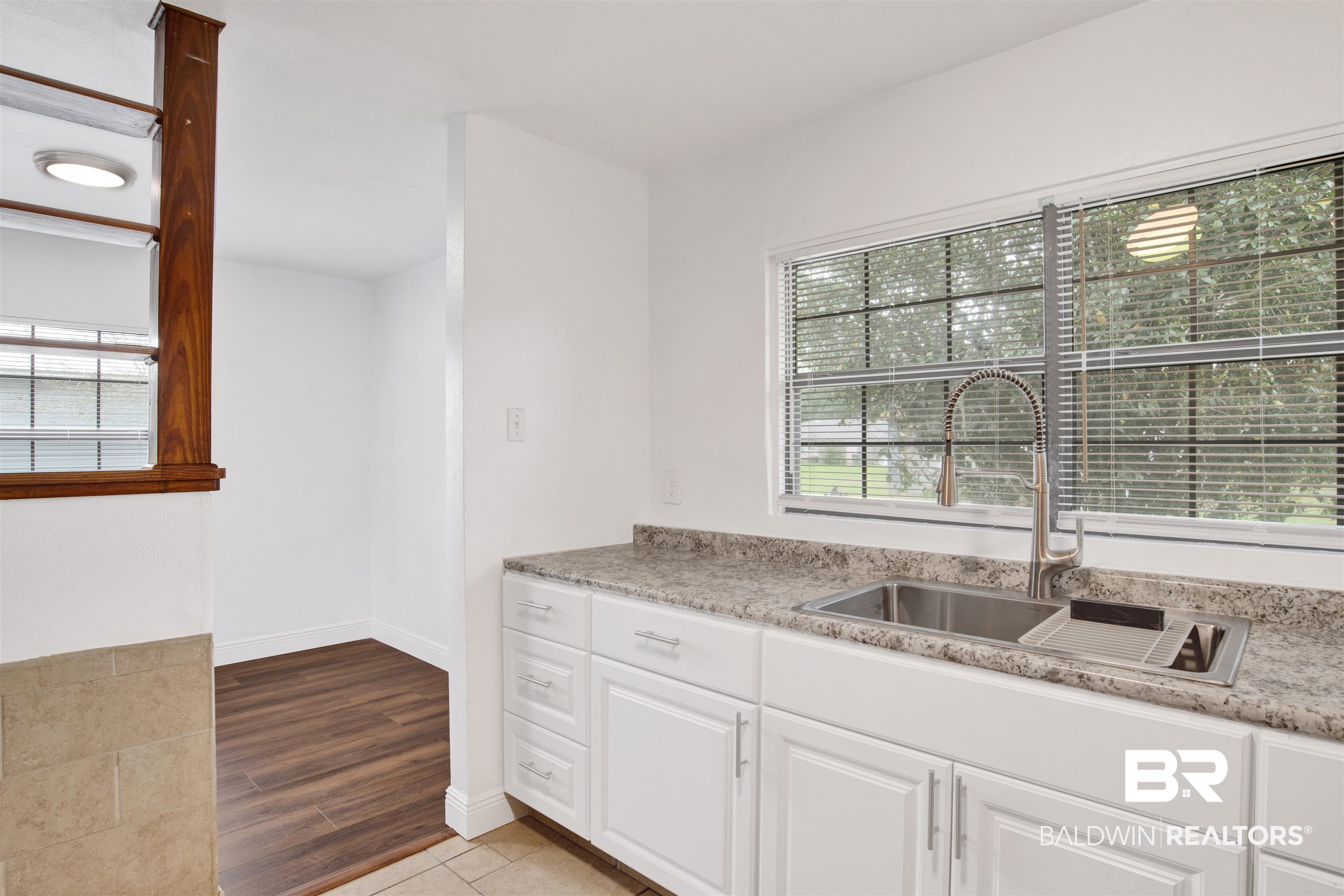 311 West Myrtle Avenue Foley, AL 36535 - Photo 13 of 22 Kitchen featuring sink, light hardwood / wood-style floors, and white cabinets