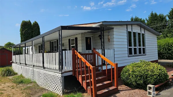 a view of a house with wooden fence next to a yard