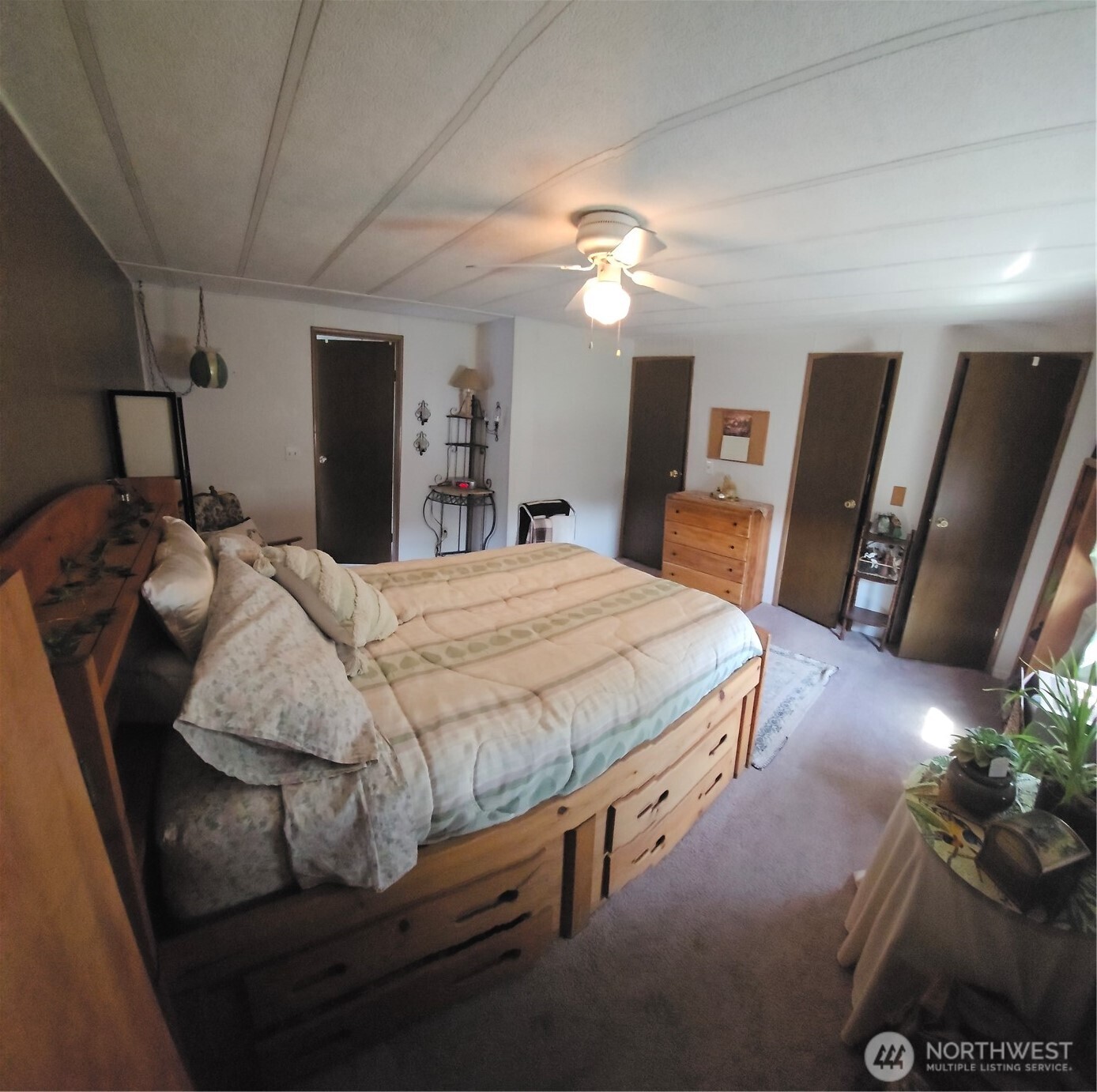 5600 Mt Solo Road, Unit 161 Longview, WA 98632 - Photo 9 of 17 a bedroom with a bed a mirror on dresser and a chandelier