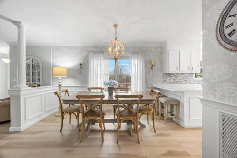 a view of a a dining room with furniture window and wooden floor